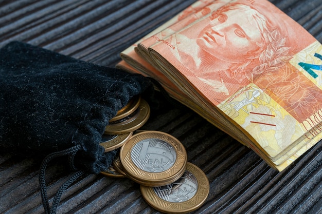 A close-up shot of Brazilian currency (Real) alongside a calculator and a financial newspaper, emphasizing the practical impact of the Selic rate on everyday financial calculations.