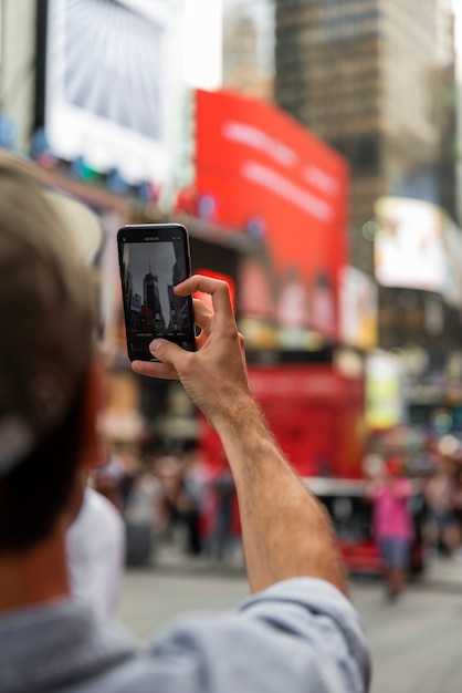 A close-up image of a smartphone screen showing the Caixa Tem app, highlighting the Bolsa Família section, amidst a blurred background of a bustling urban center in Brazil.