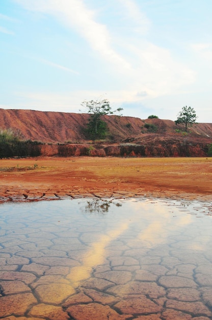 Empty reservoir showing cracked earth and low water levels, illustrating the severity of a drought affecting water supply in a Brazilian region.