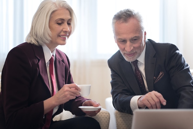 A close-up shot of a financial advisor explaining retirement plans to a middle-aged couple in a modern office setting. The atmosphere should be professional and trustworthy.