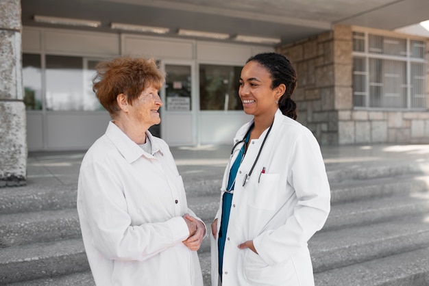 A doctor in a white coat consulting with a senior patient in a public hospital setting in Brazil. The focus is on the doctor-patient relationship and the importance of quality care in public health.