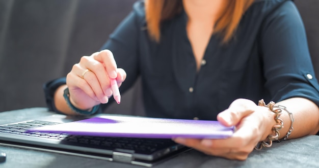 A close-up shot of a Cadastro Único registration form being filled out by a woman with a concerned expression. Focus on the details of the form and the woman's hands, emphasizing the importance of accuracy and attention to detail.
