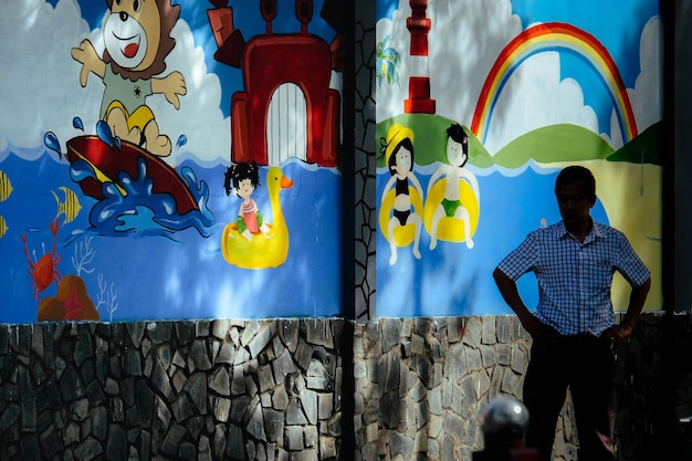 A large-scale street art installation in Rio de Janeiro, created by a social project, depicting portraits of local residents and celebrating the diversity of the community. The artwork is vibrant and eye-catching, transforming a previously dull and neglected street into a colourful and engaging public space.