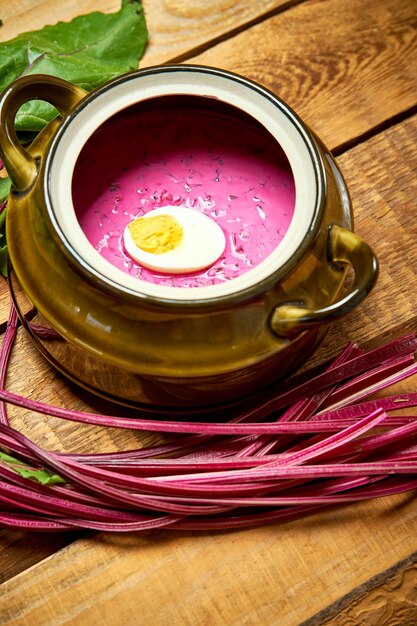 A close-up shot of Tacacá being served in a traditional gourd bowl, with visible jambu leaves and yellow Tucupi broth. The steam rising from the bowl enhances the sense of warmth and authenticity.