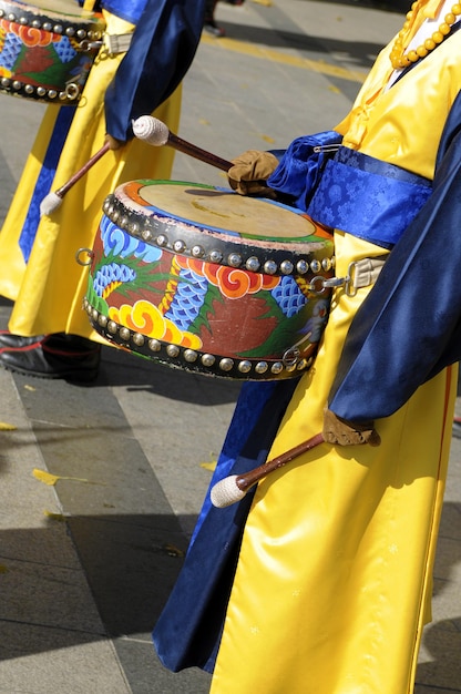 A close-up shot of a colorful Maracatu parade in Recife, Brazil, with dancers wearing elaborate costumes and headdresses, accompanied by musicians playing drums and percussion instruments.