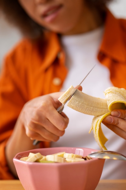 A close-up of a street vendor in Belém, Brazil, preparing a bowl of açaí topped with granola and sliced banana, showcasing the modern presentation of this traditional Amazonian food.
