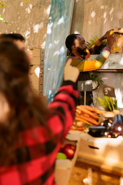 Brazilian artist standing proudly in front of their work at an open-air market, with a diverse crowd appreciating the art.