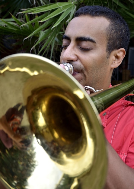 A close-up shot of a skilled Brazilian percussionist playing the surdo drum during a samba performance. The image shows the intricate details of the instrument and the musician's focused expression, capturing the essence of Afro-Brazilian musical expression.