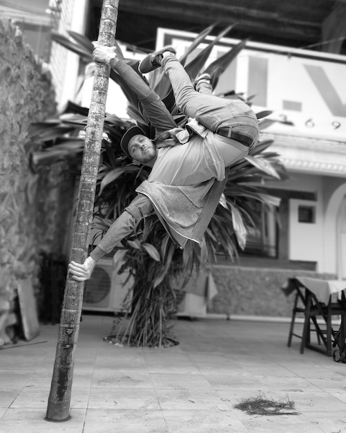 A black and white photograph capturing a roda de capoeira in Bahia, Brazil, in the early 20th century. Men are playing berimbaus and singing traditional capoeira songs, showcasing the fusion of African martial arts and music as a form of cultural resistance.