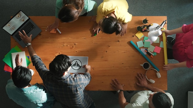 A bird's-eye view of a team brainstorming session led by [Nome de Personalidade Brasileira]. The scene showcases collaboration, creativity, and strategic planning.