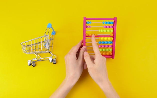 A hand holding a shopping basket with diverse items, with a faint overlay of mathematical equations and percentage signs, symbolizing the calculation and variations in tax rates post-reform.